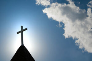 Church steeple with cross in sun