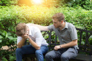 Youth pastor consoling young adult in hard time