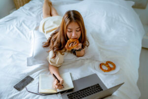 Female student studying on bed