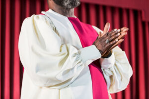 Man in robe praying in front of church