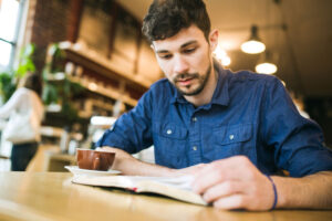 Man reading bible in coffee shop