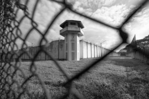 Prison watchtower through chainlink fence