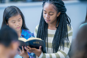 Two young adults reading bible together