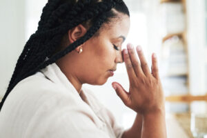 Young woman praying at home