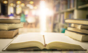 bible on library table with cross in background