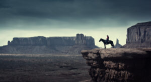 Cowboy on his horse on a cliff edge