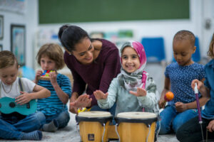 Diverse group of children playing music in class