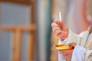 Priest offers Holy Communion