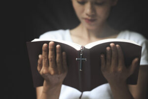 praying over scripture and cross
