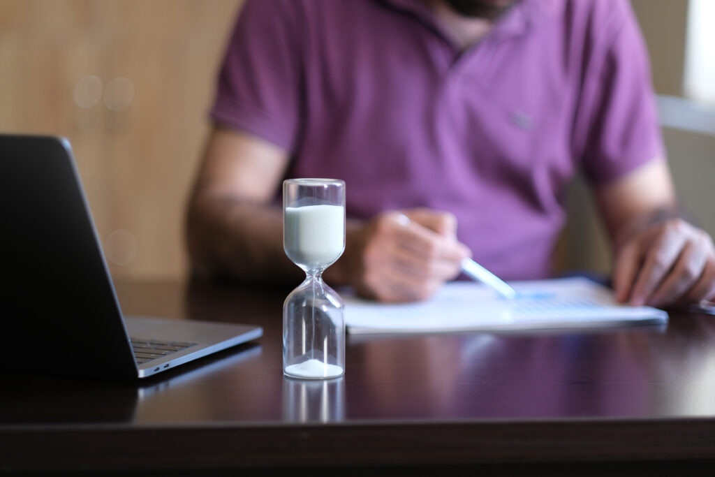 Male ministry coach working with an hourglass in front of him.